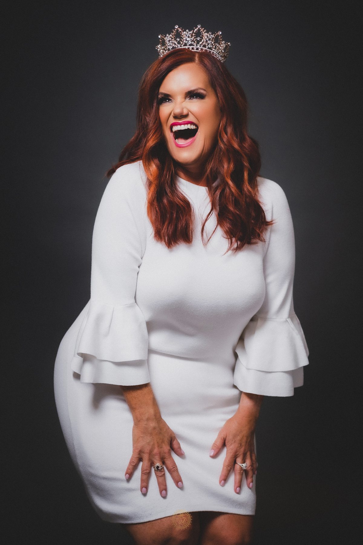 Dr. Lori C. Ebert in a white dress and crown, laughing